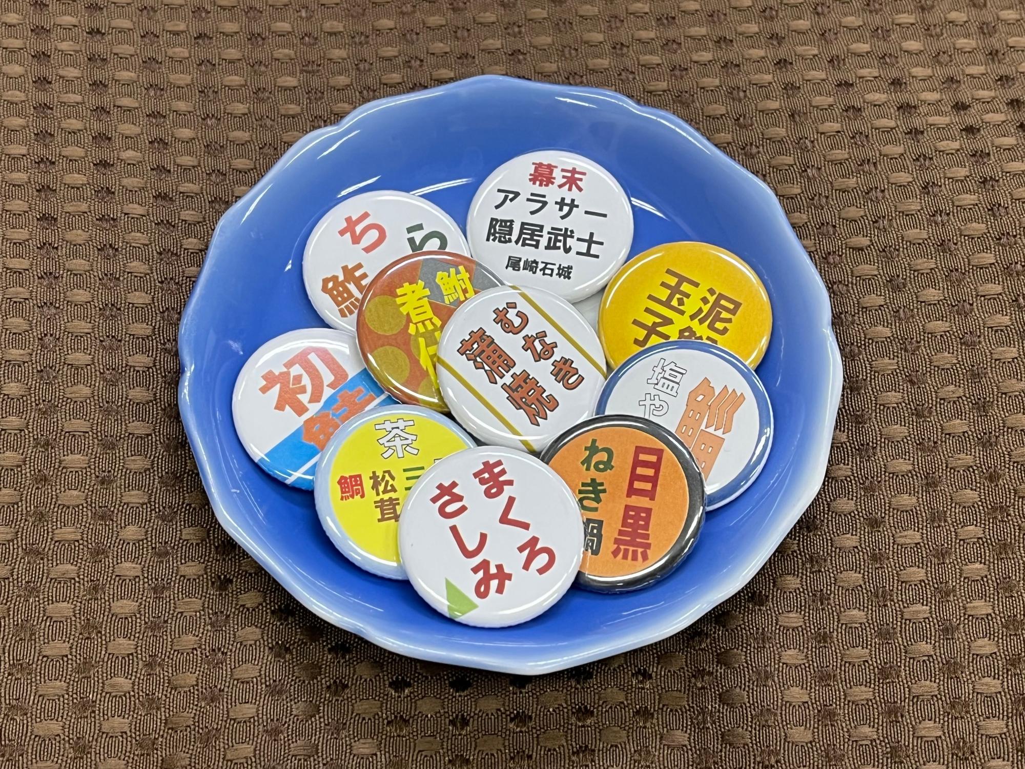 「石城日記」に出てくる江戸時代の魚料理の名前などをデザインした缶バッジ