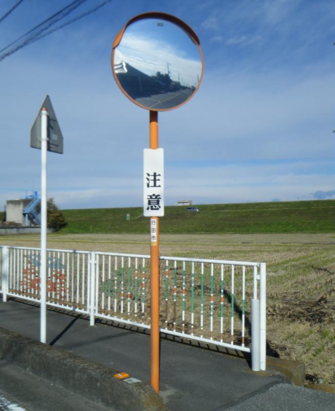歩道に設置された道路反射鏡と道路標識の写真