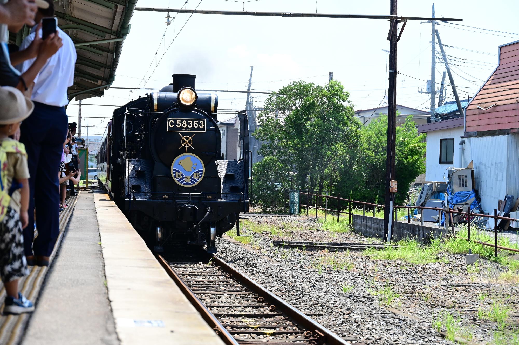 試運転の特別なヘッドマークをつけて行田市駅に入線してくるSL