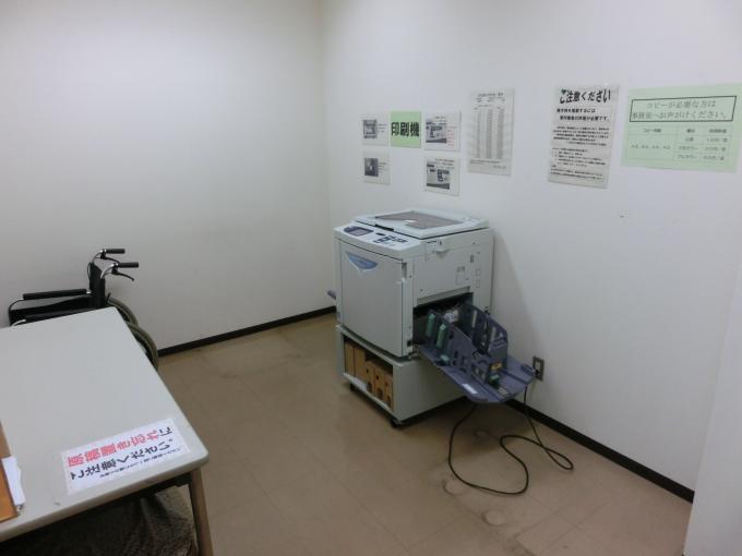 コピー機と作業台が設置された、印刷作業室の写真