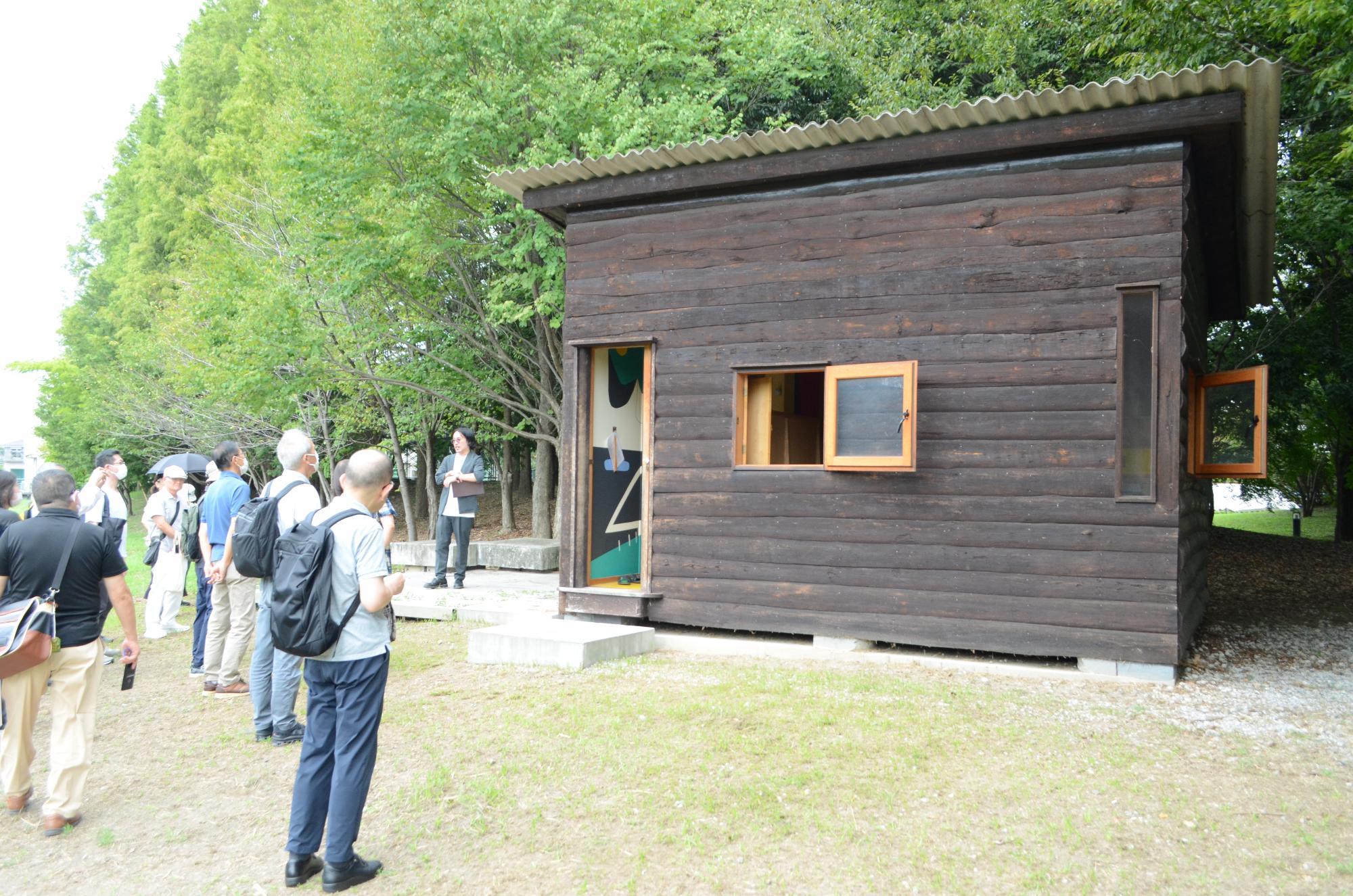 ものつくり大学内に再現されている休暇小屋を見学する参加者