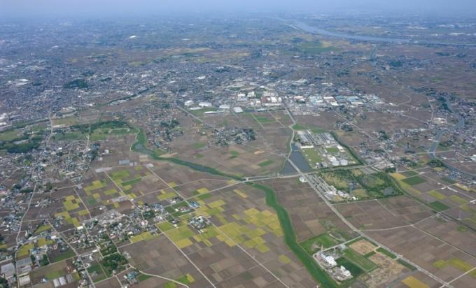 田畑や住宅地、右上には川が流れている行田市の風景を上空から写した航空写真