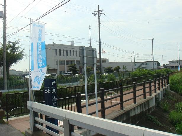 奥に公共施設のような白い建物が見えている忍川・吾妻橋の写真