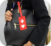 女性のバッグの取っ手にストラップの付いたヘルプマークが付けられている写真