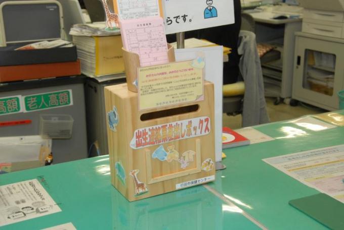 市役所の担当する窓口に設置された木製の出生連絡票差出しボックスの写真