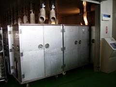 上部に配管が繋がっており、正面に扉がついているコンテナが並んで設置されているコンテナ消毒室の写真