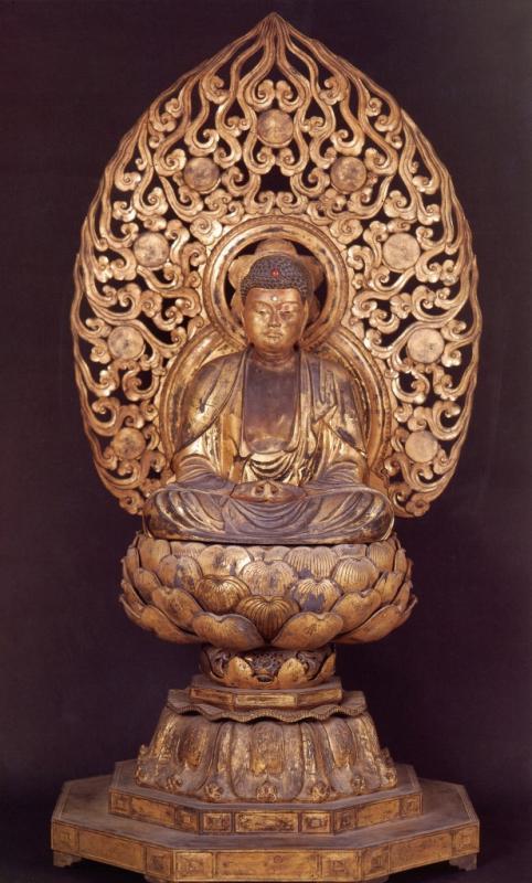 像のうしろに唐草模様の光背が立っており、蓮の花の台座に胡坐をかいて座っている木造阿弥陀如来坐像の写真