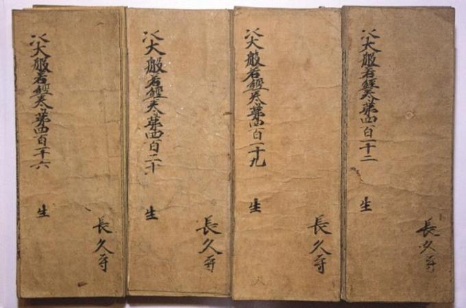 左上に「大般若波羅蜜多経」、右下に「長久寺」と墨で書かれ、古く紙が茶色に変色している折本の大般若経が4冊並んで置かれている写真
