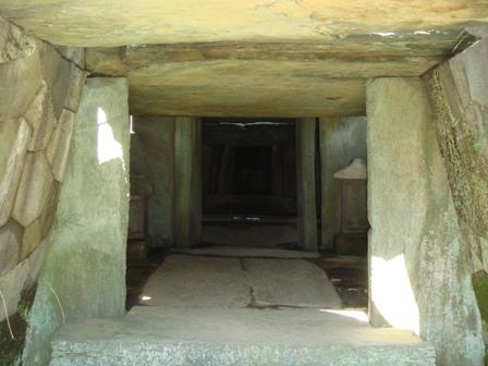 大きな白っぽい岩が箱型に積まれ奥の部屋まで続く石室が作られている八幡山古墳石室の入り口から見た内部の写真
