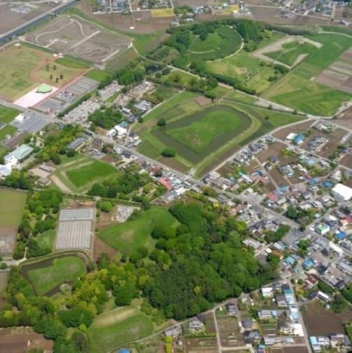 田畑や住宅の一角にある前方後円墳や円墳などからなる埼玉古墳群を上空から撮影した航空写真