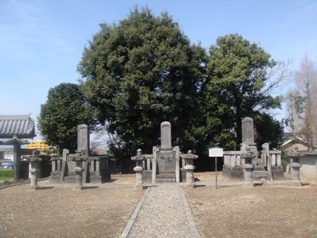 墓石の両側に石灯篭があり、3基の墓石が横に並んでいる旧藩主松平家の墓の写真