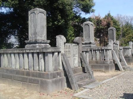 石の外柵で囲まれた同じ形の墓石が横に3つ並んでいる旧藩主松平家の墓を左側から写している写真