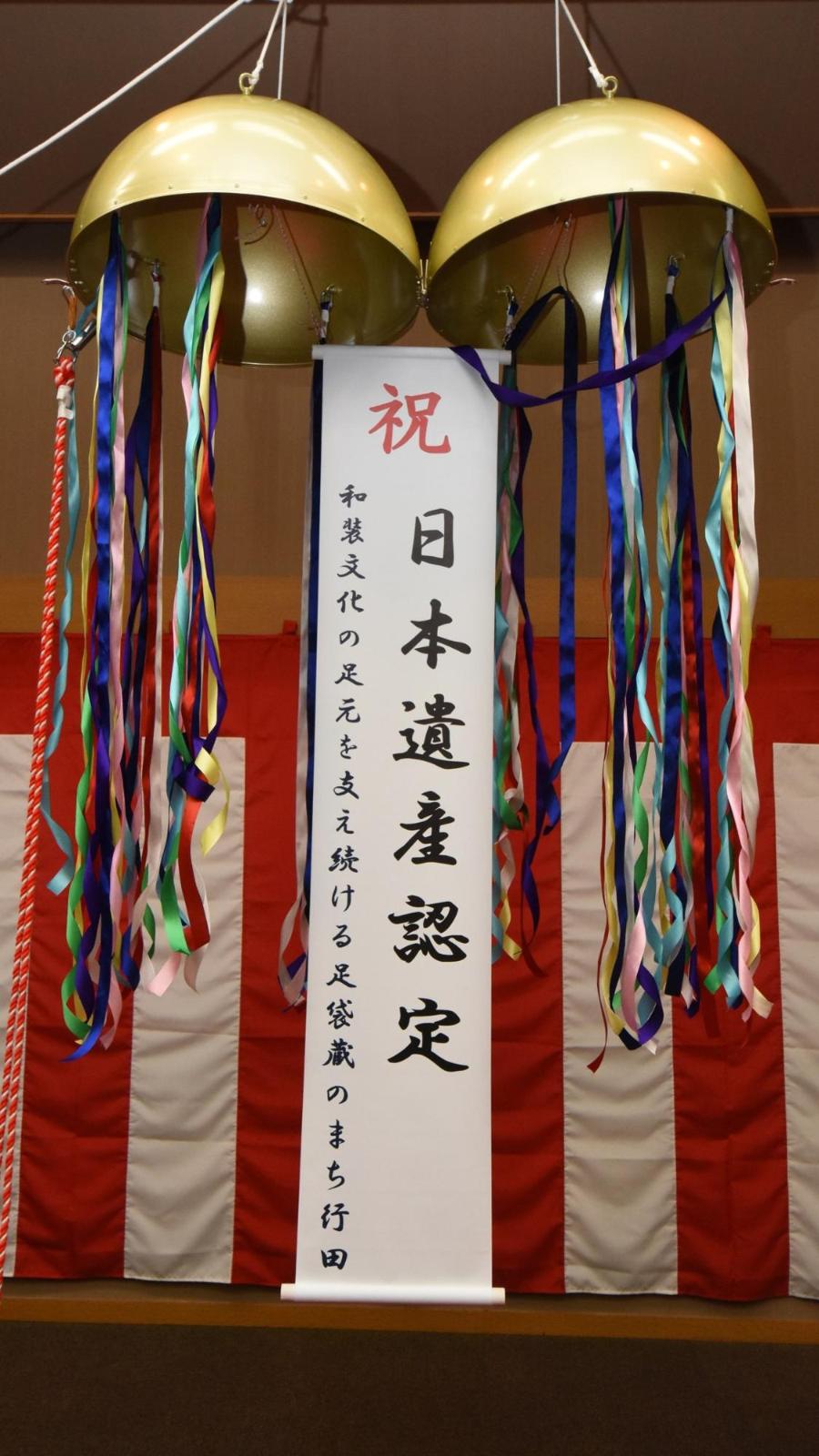 祝日本遺産認定と書かれた垂れ幕の下がったくす玉の写真