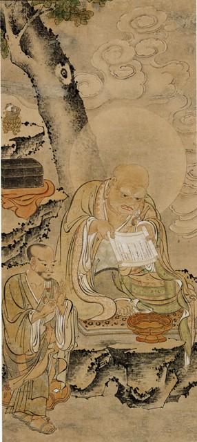 月光の下、着物を着た僧侶が切り株の上に布を敷いて座り手に経文を持って読経に努めており、傍らに着物を着て座っている男性がやわらかな線で描かれている羅漢画像の写真