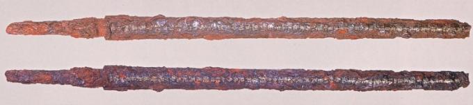 全体が赤く錆びているが剣の形が残っている2本の金錯銘鉄剣の写真