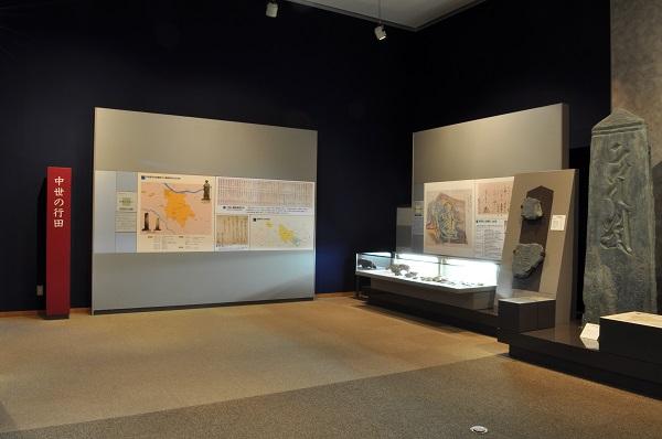 城絵図や忍城跡の発掘調査で発見された資料や戦国武将の書状、石田堤の想定図を展示している写真