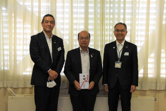 中央に目録をもっている市長、左側に大山熊谷支社長、右側に岸本埼玉本部長が立っている写真
