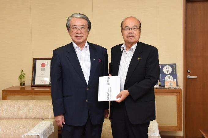 細井保雄代表取締役と寄附金を受け取った石井市長の写真