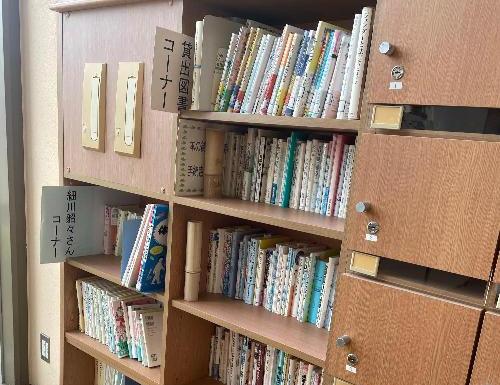 壁側の棚に本が並べられた図書コーナーの写真